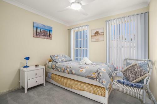 a bedroom with a bed and a window at Pier 8 by Experience Jervis Bay in Huskisson