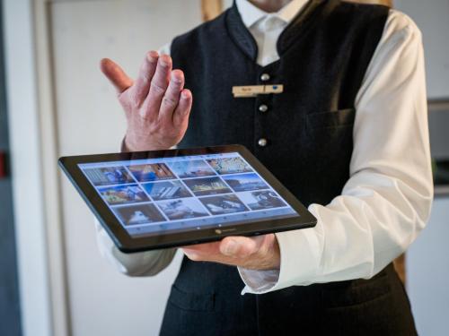 a man is holding a tablet computer with his hand at Euler Neuschönau - Naturhotel & Chalets in Neuschönau