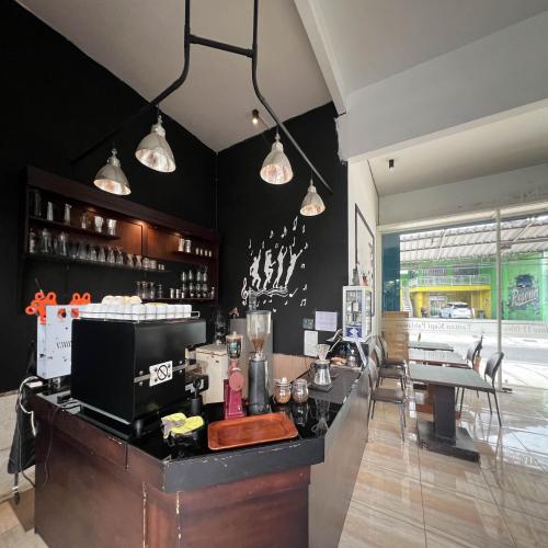 a bar in a restaurant with black walls and lights at AN Homestay Syariah Mitra RedDoorz Wonosobo in Wonosobo