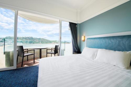 ein Schlafzimmer mit Bett und Blick auf das Meer in der Unterkunft Warwick Hotel Cheung Chau in Hongkong