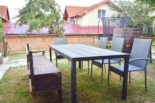 a table and chairs with a table and a bench at Casa Noastră in Cricău