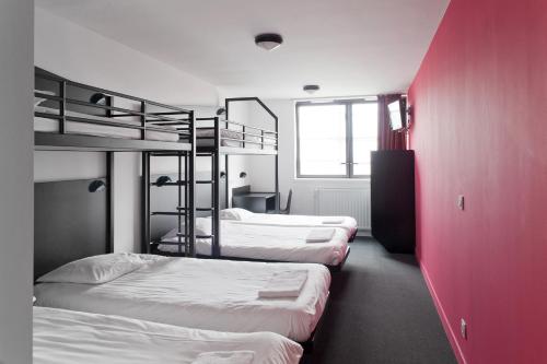 a room with three bunk beds and a red wall at Résidence Internationale De Paris in Paris