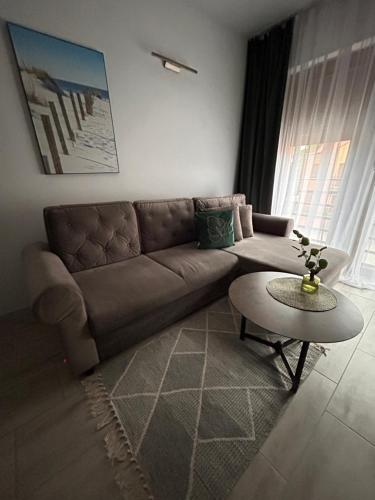 a living room with a couch and a table at Przy Złotych Piaskach 1 in Sława