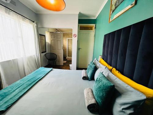 a bedroom with a large bed with a large headboard at Kate's Nest Guesthouse & Backpackers in Windhoek