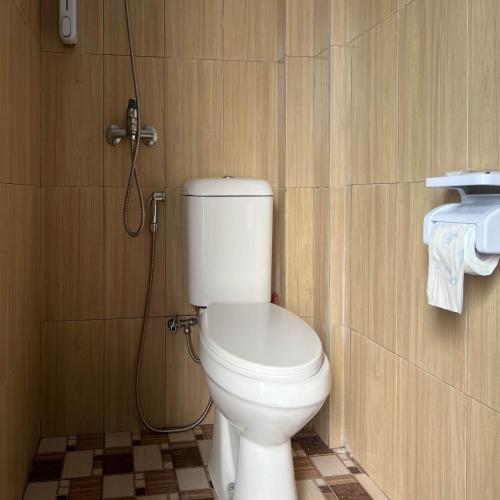 a bathroom with a white toilet in a room at AN Homestay Syariah Mitra RedDoorz Wonosobo in Wonosobo