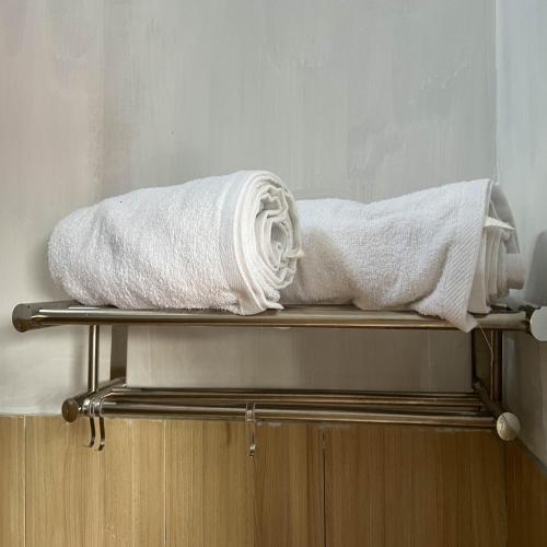 a couple of towels sitting on top of a shelf at AN Homestay Syariah Mitra RedDoorz Wonosobo in Wonosobo
