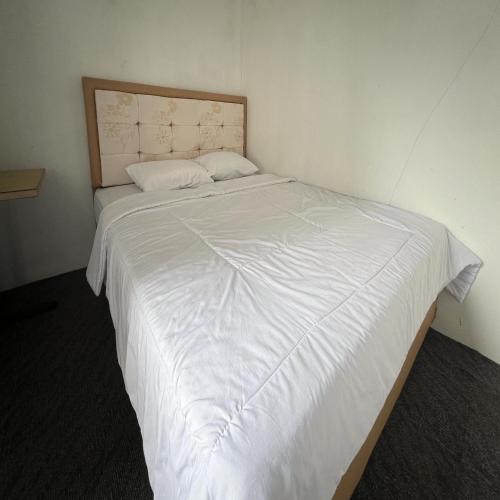a large white bed in a small room at AN Homestay Syariah Mitra RedDoorz Wonosobo in Wonosobo