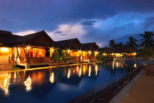 a large swimming pool in a resort at night at Sangsawan Palace Khaolak Resort in Khao Lak