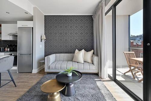 a living room with a couch and a table at Bella - Stylish 1-Bed Apt in trendy De Waterkant with Balcony in Cape Town