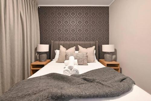 a bedroom with a large bed with two night stands at Bella - Stylish 1-Bed Apt in trendy De Waterkant with Balcony in Cape Town