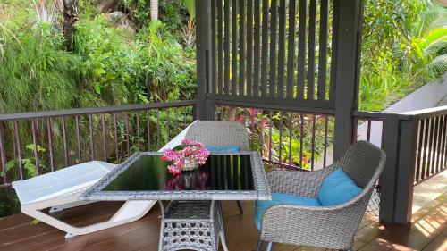 a patio with a table and chairs on a deck at Stephna Residence in Anse Boileau