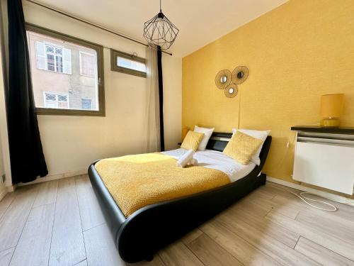 une chambre avec un lit aux murs jaunes et une fenêtre dans l'établissement Le Montjovis, spacieux et lumineux avec garage, à Limoges