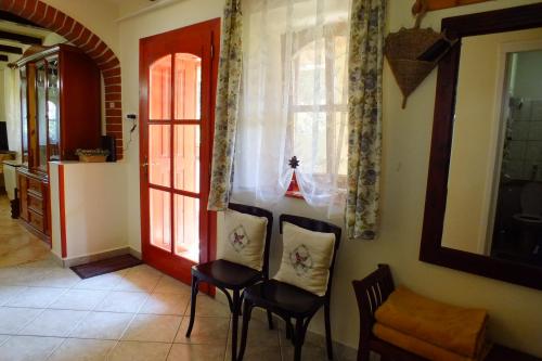 a room with two chairs and a red door at Tulipán Ház in Bodony