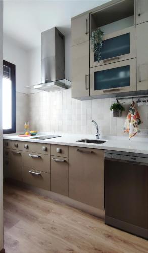 a kitchen with white cabinets and a sink at Casa Yaye Puerta Palma - Écija in Écija