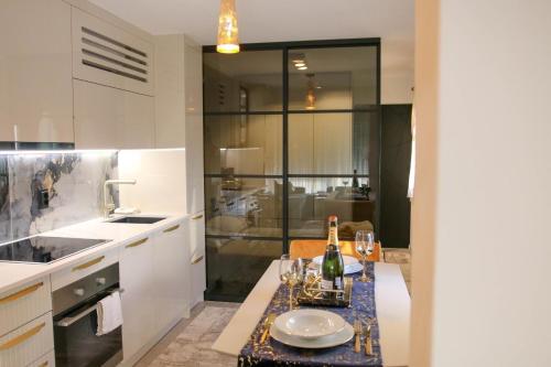 a kitchen with a table with a bottle of wine at PORTA AUREA Našice in Našice