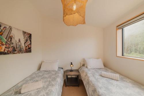 two twin beds in a room with a window at Ocean Views at Rapanui Lodge- 4BR Gem with Parking in Christchurch