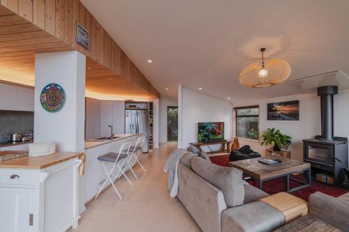 a kitchen and living room with a couch and a table at Ocean Views at Rapanui Lodge- 4BR Gem with Parking in Christchurch