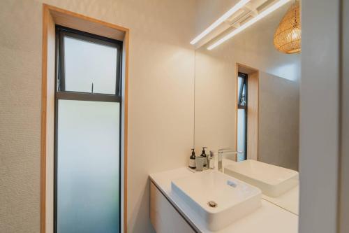 a bathroom with a white sink and a mirror at Ocean Views at Rapanui Lodge- 4BR Gem with Parking in Christchurch