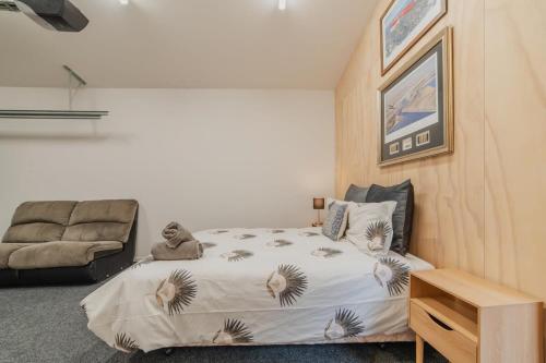 a bedroom with a bed and a couch at Ocean Views at Rapanui Lodge- 4BR Gem with Parking in Christchurch