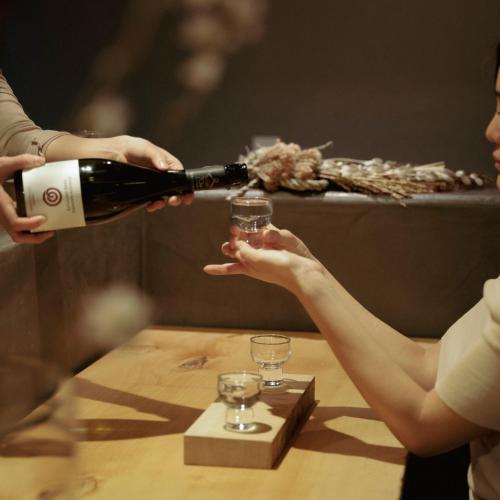 a woman pouring a glass of wine on a table at THE SENSE HOTEL TOKYO in Tokyo
