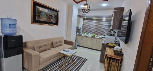 a living room with a couch and a kitchen at Rivaj palace in Niāziān