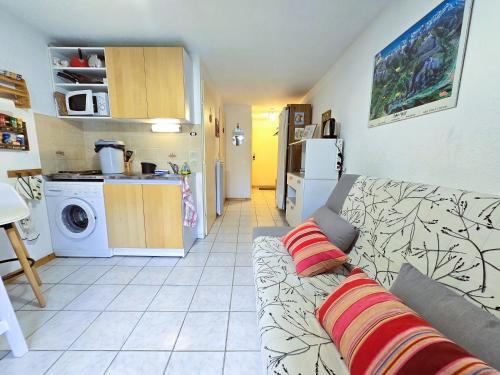 un salon avec un canapé et une cuisine dans l'établissement Le Hameau des Neiges, à Morillon