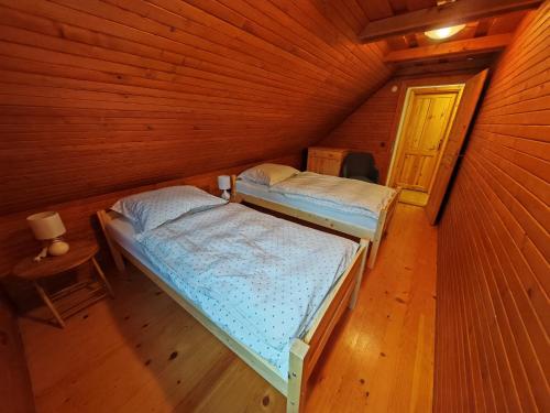 a room with two beds in a wooden cabin at Chata KORSO v súkromí so záhradou 1200m2 in Terchová