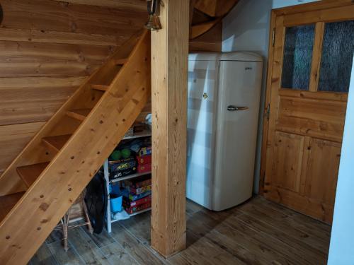 a staircase leading up to a refrigerator in a room at Chata KORSO v súkromí so záhradou 1200m2 in Terchová
