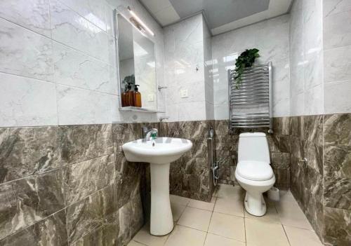 ein Badezimmer mit Waschbecken, Toilette und Spiegel in der Unterkunft City center Apartment 14 in Baku