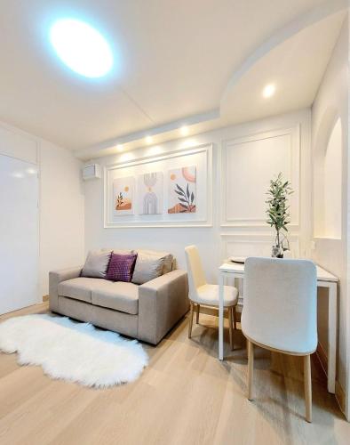 a living room with a couch and a table and chairs at Joyful room in Ban Song Hong