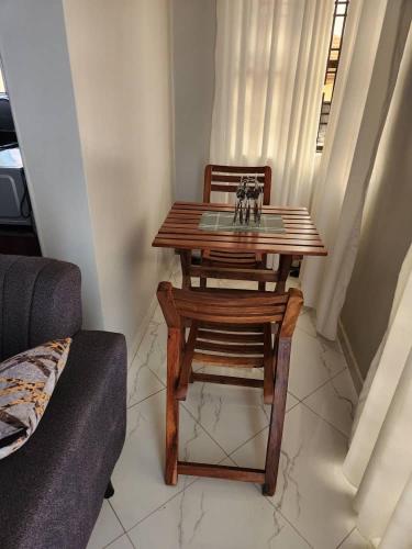 a wooden table and chair in a living room at Abba Homes in Bulambiro