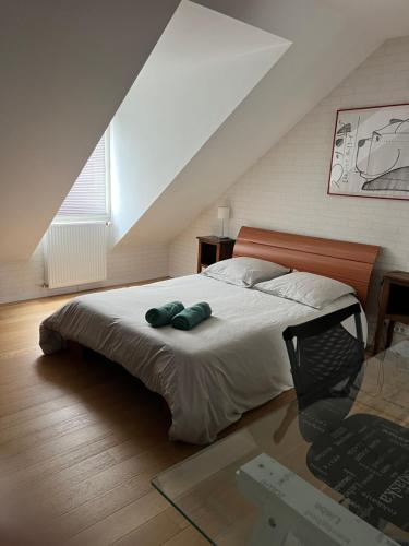 une chambre avec un lit avec deux oreillers verts dessus dans l'établissement La douceur Angevine !, à Les Ponts-de-Cé