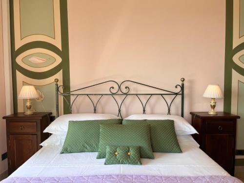 a bedroom with a bed with two green pillows at Belvedere Bike Hotel in Montà