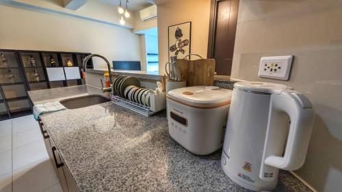 马尼拉EG Private House -BGC UPTOWN的厨房配有带水槽和门廊的台面