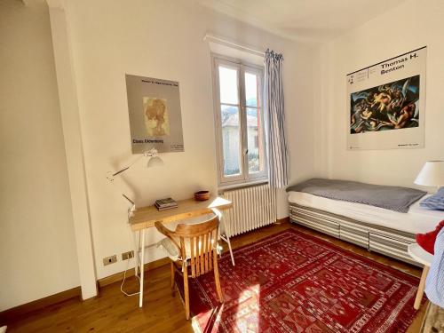 a bedroom with a desk and a bed and a window at Casa Tranquilla in Cannobio