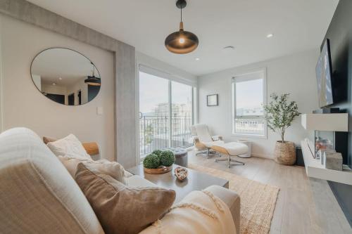 a living room with a white couch and a mirror at Penthouse Perfection - 2BR Elegance on Worcester St in Christchurch