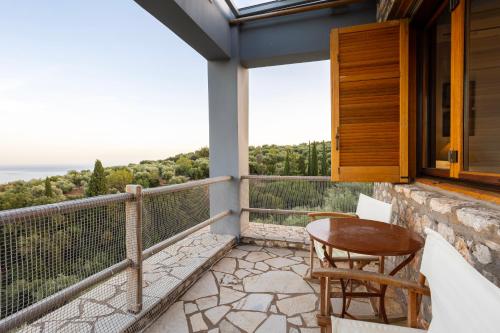 a balcony with a table and chairs and a view at Stone Farmhouse in Groves - Sea & Mountain Views in Kalamaki Messinia