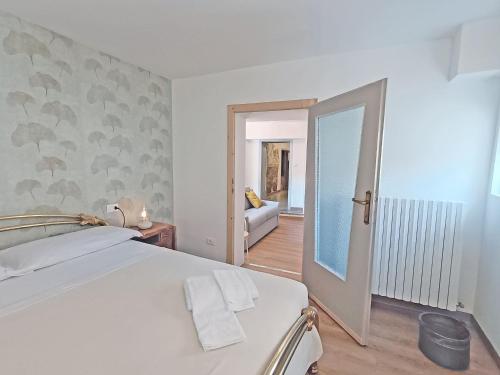 1 dormitorio con 1 cama y una puerta que conduce a la sala de estar en Ca' Ma' Holiday Lecco Lake Como, en Lecco