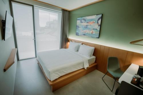a small bedroom with a bed and a window at Jiro Hotel in Bandung