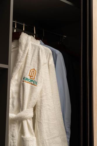 a white sweatshirt hanging on a rack in a closet at Kiropol Hotel & Restaurant in Dushanbe