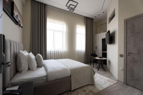 a bedroom with a bed and a window and a desk at Kiropol Hotel & Restaurant in Dushanbe