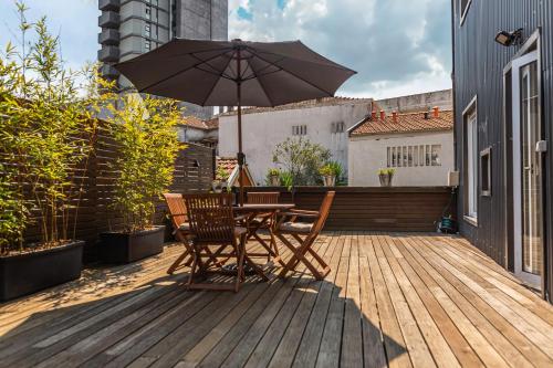 een houten terras met een tafel en een parasol bij Bonjardim Terrace in Porto