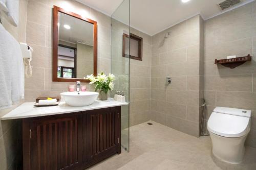 a bathroom with a sink and a toilet and a shower at Palm Garden Beach Resort & Spa in Hoi An