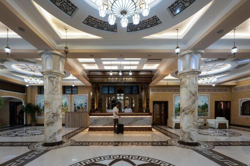 a lobby of a hotel with a person standing in the lobby at Kiropol Hotel & Restaurant in Dushanbe