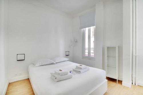 - une chambre blanche avec un grand lit blanc et des serviettes dans l'établissement Comfortable flat near Paris - Suresnes, à Suresnes