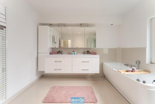 a bathroom with a tub and a sink and a mirror at Maison La Roussette - in the heart of Nieuwpoort in Nieuwpoort