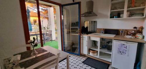 a small kitchen with a table and a refrigerator at Appartement KEYSTONE BIBA in Libourne