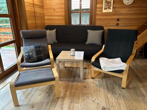 two chairs and a couch and a table in a room at Chata KORSO v súkromí so záhradou 1200m2 in Terchová