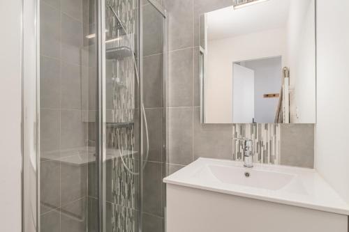 une salle de bain avec un lavabo et une douche avec un miroir dans l'établissement Superbe T2 Loft 1, à Marseille