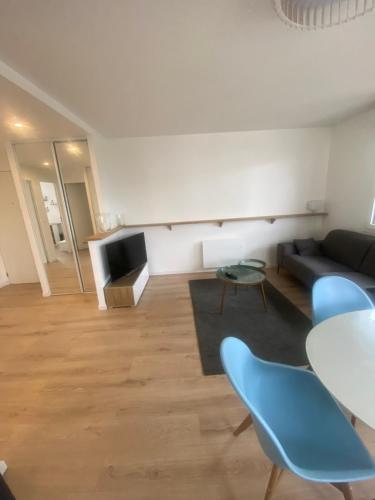 un salon avec un canapé, une table et des chaises dans l'établissement AG Immobilier 95, à Bezons